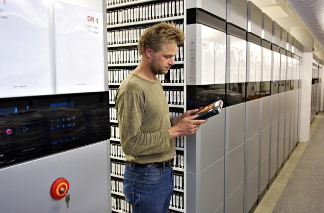 Employee among shelves with videotape
