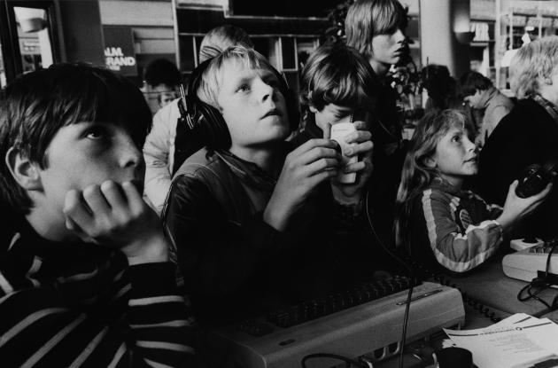 Children play computer games. Black and white photo.