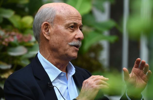 Photo of Jeremy Rifkin gesturing in front of a green space