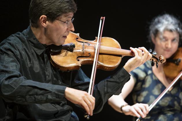 To violinister spiller på scenen i Dronningesalen