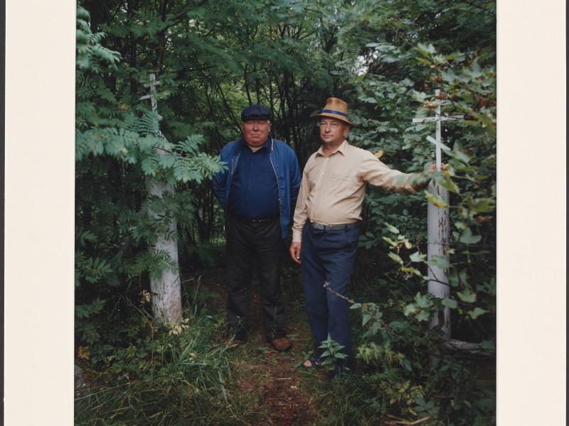 To mænd med hat omringet af grønne træer