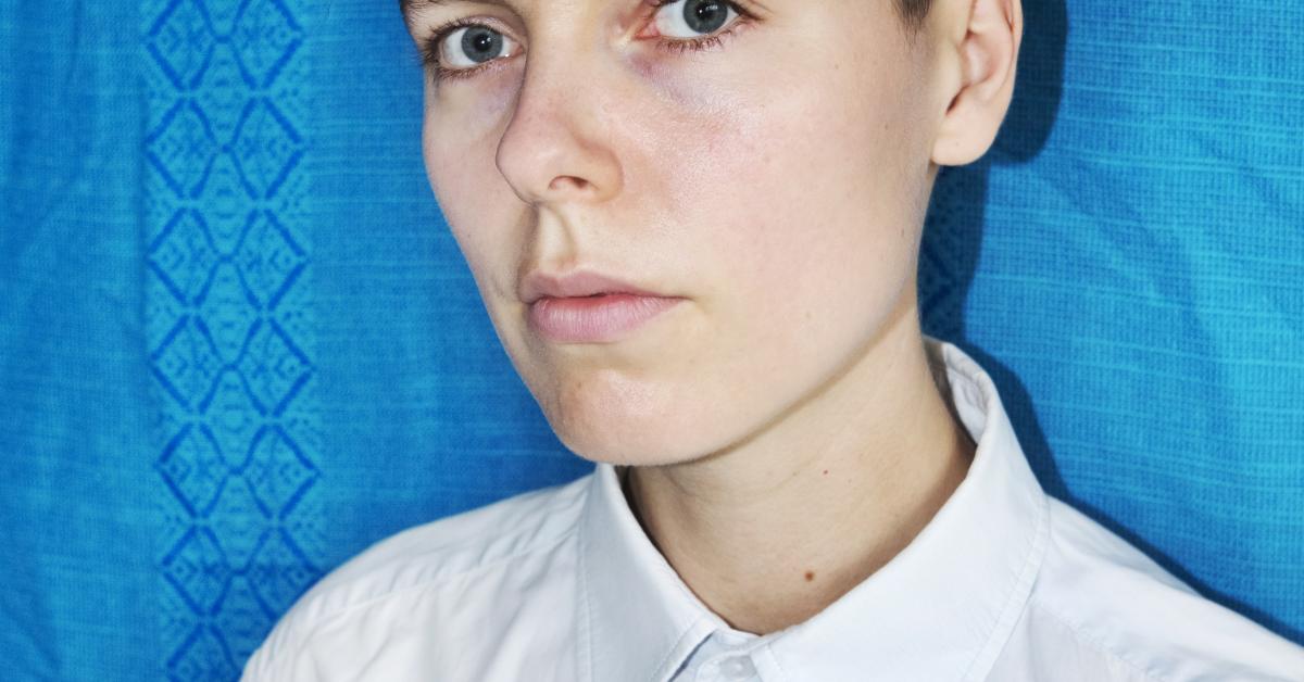 A man in a white shirt in front of a blue background